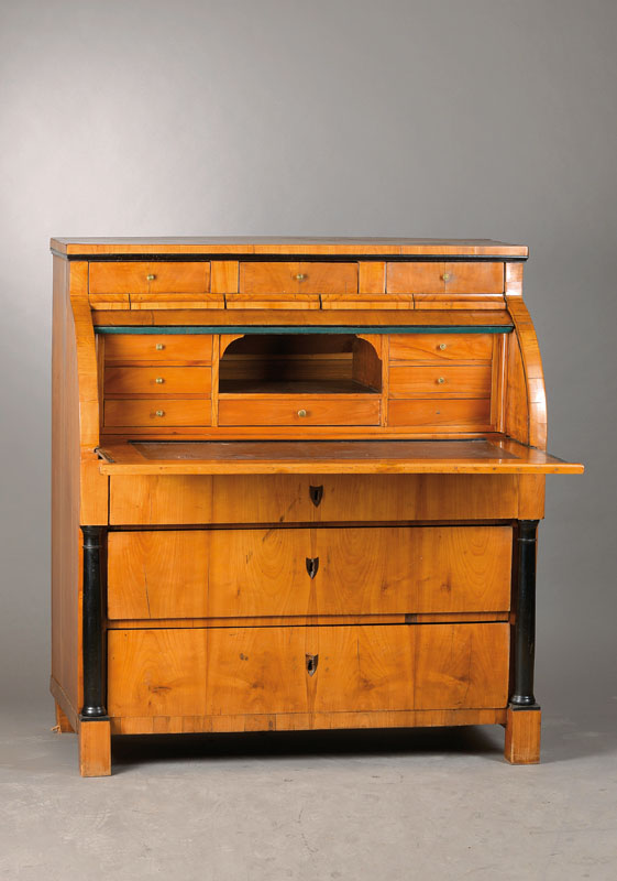 Zylinderbureau, wohl Rheinland um 1820/25, Kirschbaumfurnier auf Weichholzkorpus z.T. 3- fach doppelt gespiegelt verlegt, Kopf horizontal 3-schübig, ...