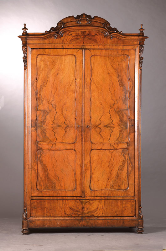 Louis-Philippe-Schrank um 1870 , Nussbaum furniert, 2-türig mit Sockelschub, abgeflachteKanten mit Wellenprofil u. Akanthusrollen, geschwungene ...