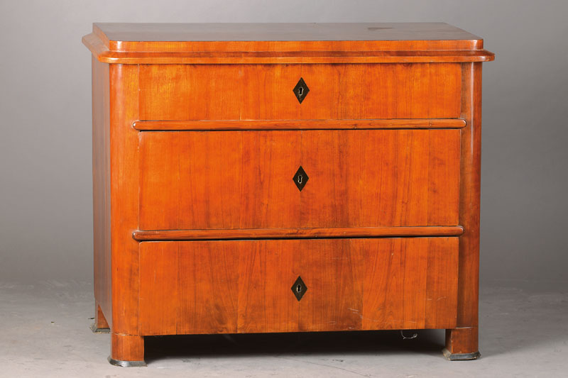 Biedermeierkommode, wohl Sachsen-Anhalt, um 1830/35,Nussbaum/Kirschbaum furniert, abgeschrägte Ecken, abfallendes Kantprofil, 3 -schübig, orig. ...