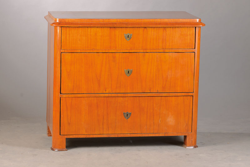 Biedermeierkommode, wohl Sachsen-Anhalt, um 1830/35, Birke auf Weichholzkorpus furniert, abgerundete Ecken, abfallendes Kantprofil, 3-schübig, ...