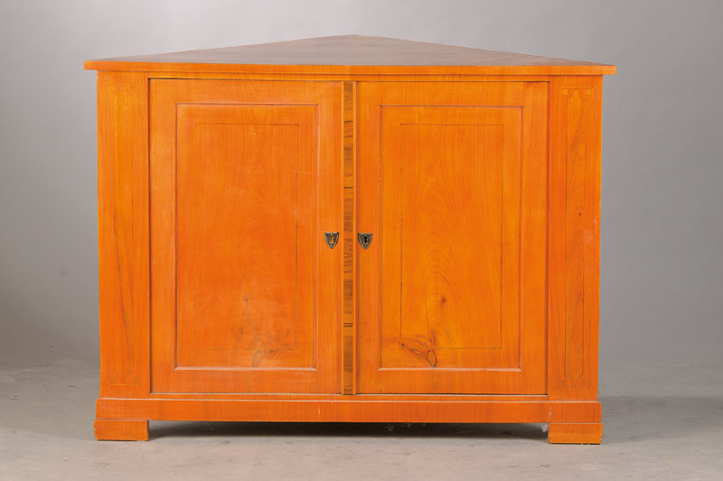 Eckschränkchen, wohl in älterer Zeit zum Eckschrank umgebaut, Kirschbaumfurnier gespiegelt verlegt, 2-türig, ein Einlegebrett, Schloss sek., ...