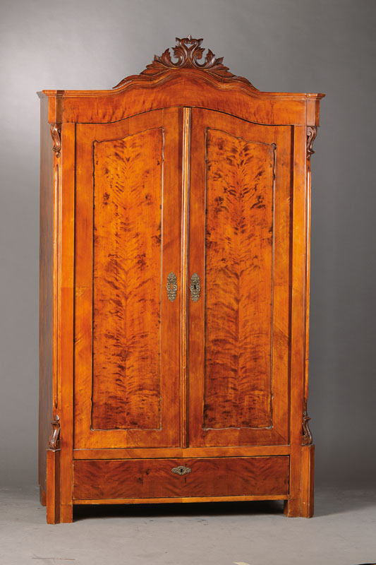Louis-Philippe-Schrank, wohl mitteldeutsch, um 1860,Birkenfurnier z.T. doppelt gespiegelt verlegt, Akanthusblattbekrönung, Brezelfüllungen, Ecken ...