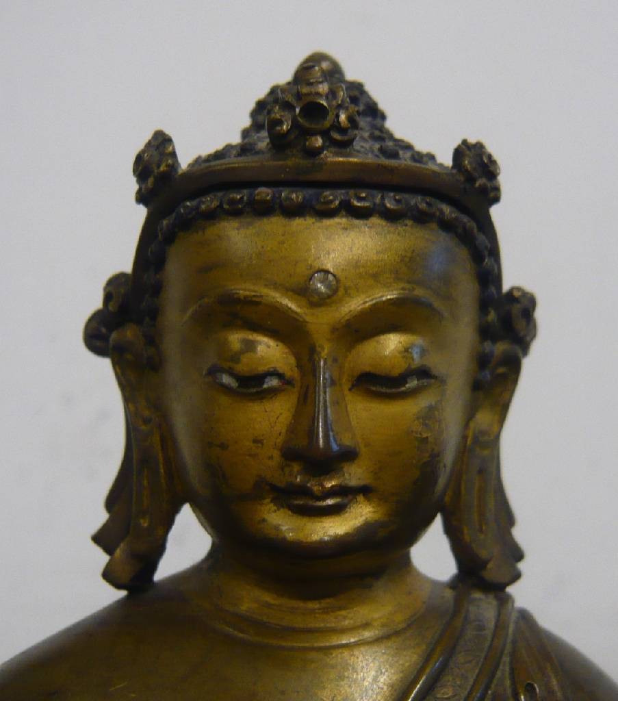 Detail b: Sitzender Buddha, Tibet, 19. Jh., Bronze, Kopf und Haare mit Resten alter Bemalung, kleiner Diamant? als drittes Auge auf der Stirn, H. 15 cm