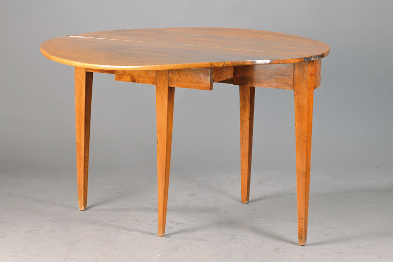 Halbmondtisch, süd-/ südwestdeutsch, um 1815/20, wild geflammtes Nussbaumfurnier, Platte aufklappbar u. durch Zargenschub gestützt, Reste alten ...