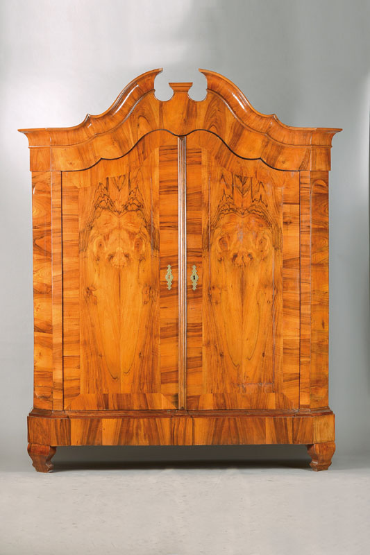 Barockschrank, wohl Schleswig-Holstein, um 1770/80, Nussbaum- bzw. Wurzelnussfurnier gespiegelt verlegt auf Eichekorpus, geschweift gekröpfter ...