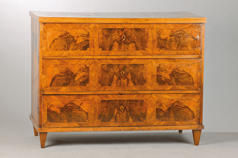 Louis-Seize-Kommode, süddeutsch, um 1770/80, Nussbaumfurnier auf Kreuzfuge verlegt, 14 Wurzelnussfurnierfelder in verkröpften Rechteckeinlagen, ...
