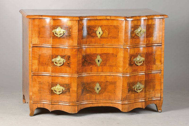 Barockkommode, mitteldeutsch, Gegend Würzburg,um 1760, Nussbaumfurnier auf Weichholzkorpus, Front geschweift u. 4-fach verkröpft, 3 Schübe je mit ...