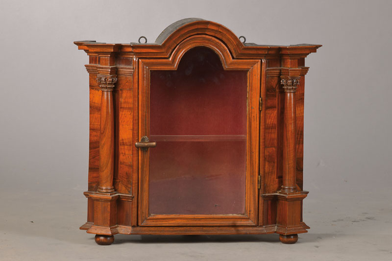 Hängevitrine, um 1720, Nussbaumfurnier auf Eiche, Mittelteil wohl ehemals Teil eines Tabernakels o.ä., seitl. Vollsäulen ebenfalls aus der Zeit, ...
