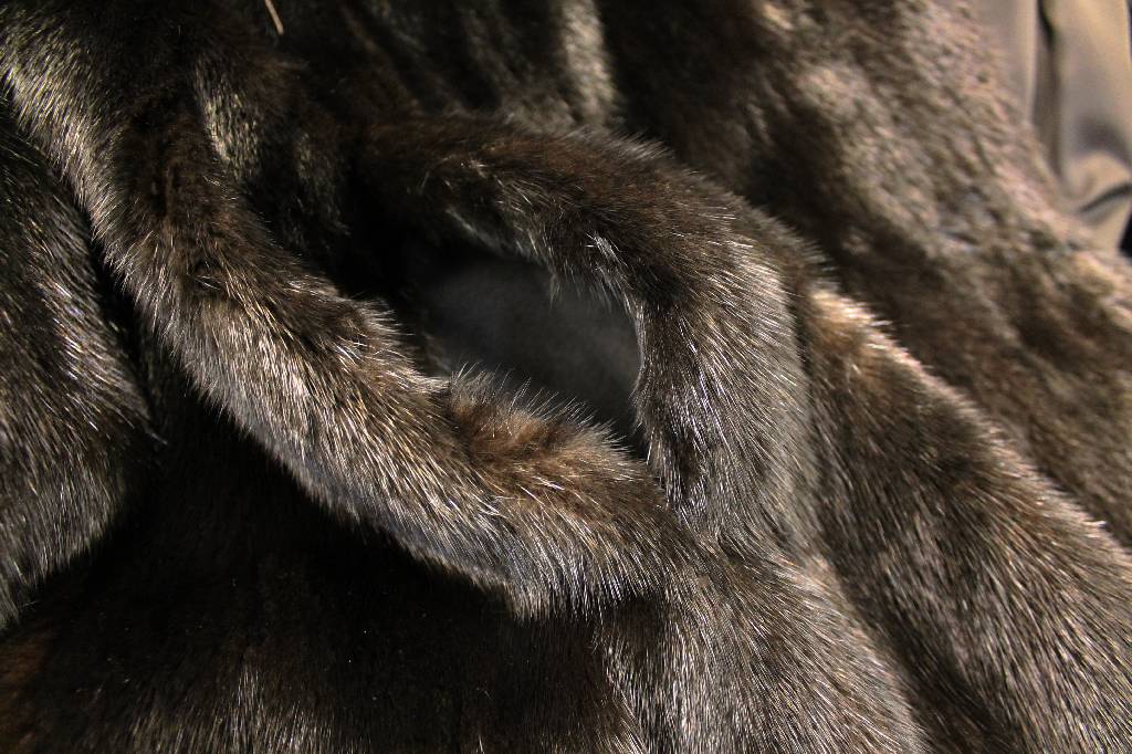 Detail f: Nerzmantel, Gr. ca. 44/46, schwarze Felle längsverarbeitet, ausgestellte Form, großer Kragen mit Zierknopf, Ärmel mit Manschetten, 2seitl. ...