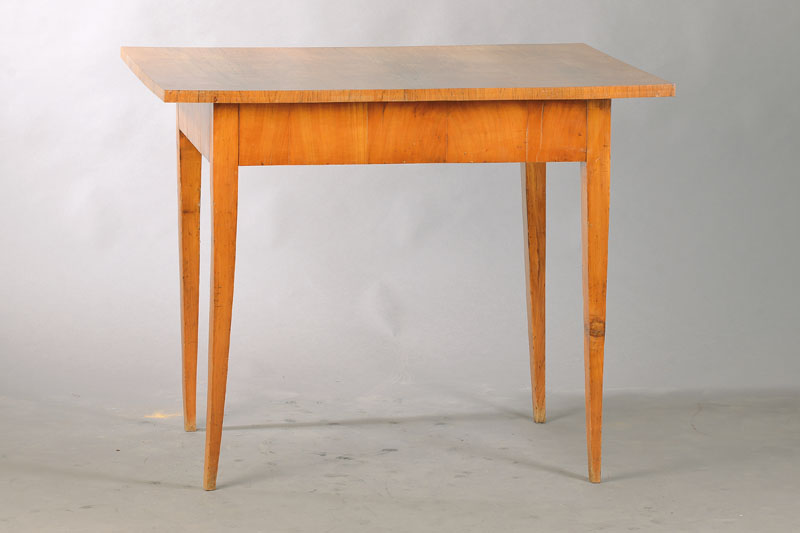 Biedermeiertischchen, süddeutsch, um 1815/20, Nussbaum massiv u. 3-fach gespiegelt furniert, mit verstecktem Zargenschub , konische Vierkantbeine, ...