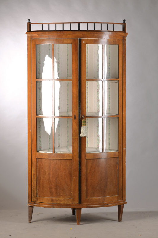 Eckvitrine, mittel- bis norddeutsch, um 1815/20, Buchefurnier auf Weichholzkorpus, 2-türigalt verglast (gewölbtes Glas), Innen 3 Einlegebretter, ...