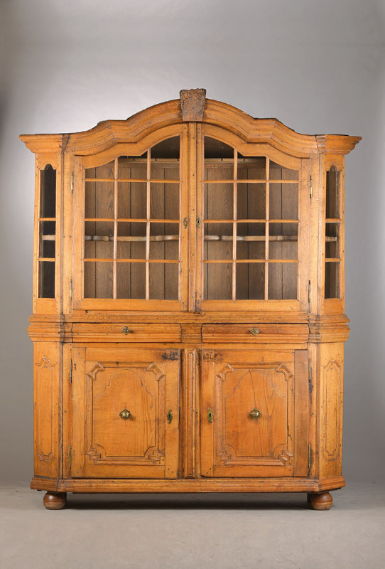 Aufsatzvitrine, Bergisches Land, um 1800, Eiche massiv, vielfach geschweift u. verkröpfterGiebel, 3-seitig verglast u. 2-türiger Vitrinenteil, ...