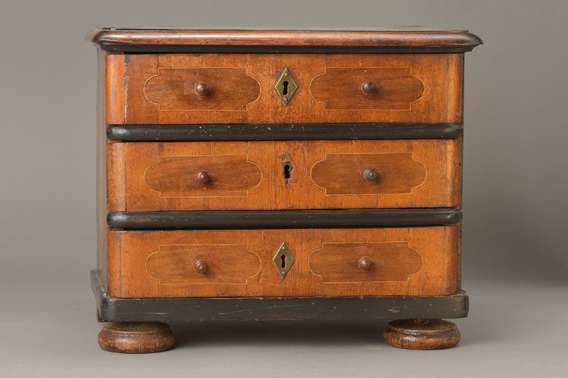 Miniaturkommode um 1780, aus Schlossbesitz,, Nussbaumfurnier auf Weichholzkorpus, Ahornfaden, Rosenholzbänder, 3-schübig mit orig. ...