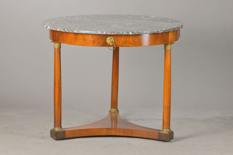 Salontisch im Empire-Stil, wohl Frankreich, um 1870, Mahagonifurnier auf Eichekorpus, 3- fach konkave Sockelplatte mit Messingbasen u. -kapitellen, 1 ...