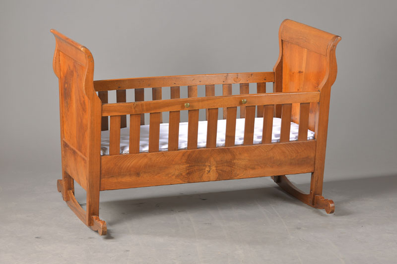 Kinderwiege, süddeutsch, um 1820/30, Nussbaum u. Weichholz, Kopf- u. Fußteil ausgeschweift, Füllung in gespiegeltem Nussbaumholz, Kufen ...