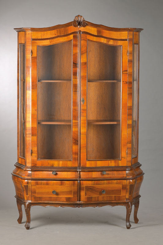 Aufsatzvitrine im Barockstil, Frühes 20.Jh.,Nussbaumfurnier auf Buchekorpus, 2-türig, 3- seitig verglast, bombierter Unterbau mit 4 Schubladen u. ...