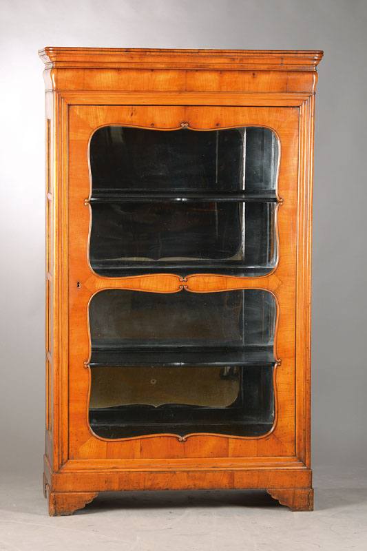 Vitrine, wohl Pfalz / Baden, 1835/40, Kirschbaumfurnier auf Weichholzkorpus, 3-seitig verglast,1-türig mit geschwungener u. geriefter Rahmung, ...