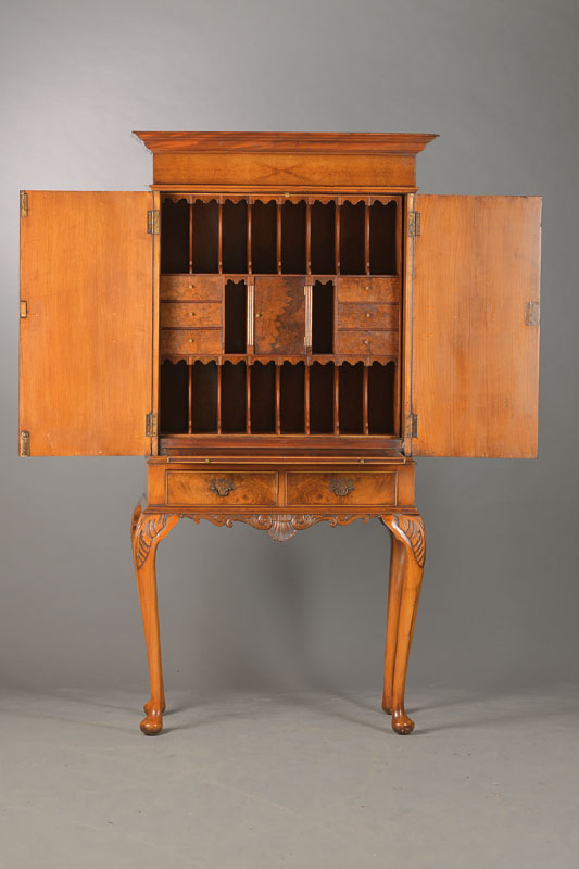 Kabinettschrank, wohl England, Mitte 20.Jh.,Nussbaum- bzw. Wurzelmaserfurnier, 2-türiges Kabinett auf hohem geschweiften Tischgestell mit 2 Schüben ...