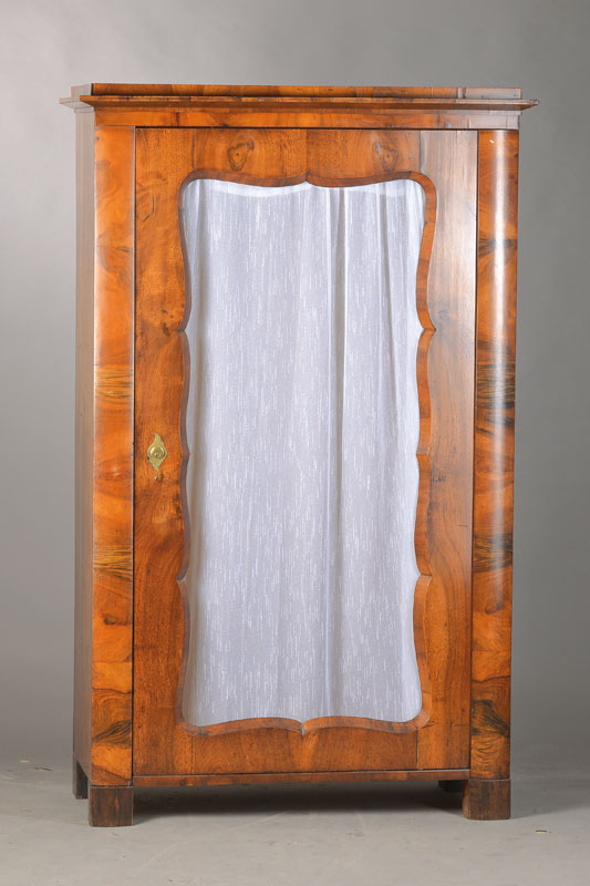 Vitrinenschrank, Österreich, um 1835/40, Nussbaum bzw. Wurzelnussfurnier auf Weichholzkorpus, 1-türig, geschwungene Brezelfüllung, Pilaster weich ...