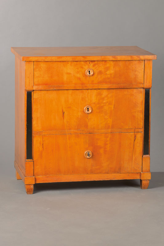 Kommode, norddeutsch, um 1830, Birkefurnier auf Weichholzkorpus, schwarz abgesetzte Pilaster, 3-schübig mit angedeutetem Überbauschub, sehr ...