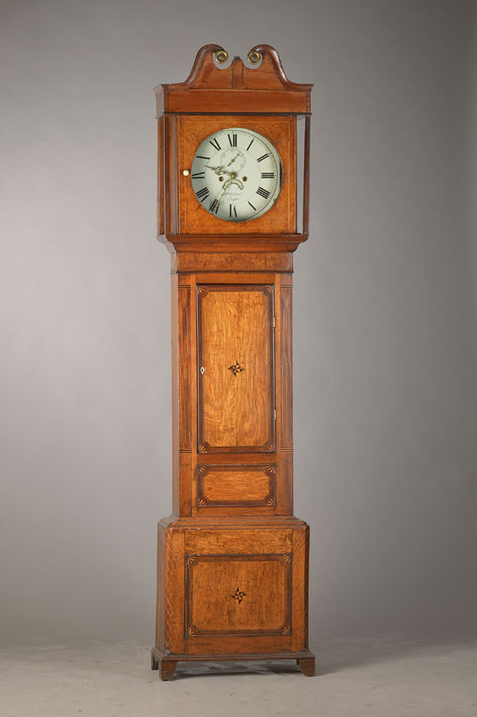 Standuhr, England um 1820, Holzgehäuse in Eiche und verschiedenen Furnieren, mit Bandintarsien und Einlegearbeiten, Sprenggiebel (kl. Verzierung in ...