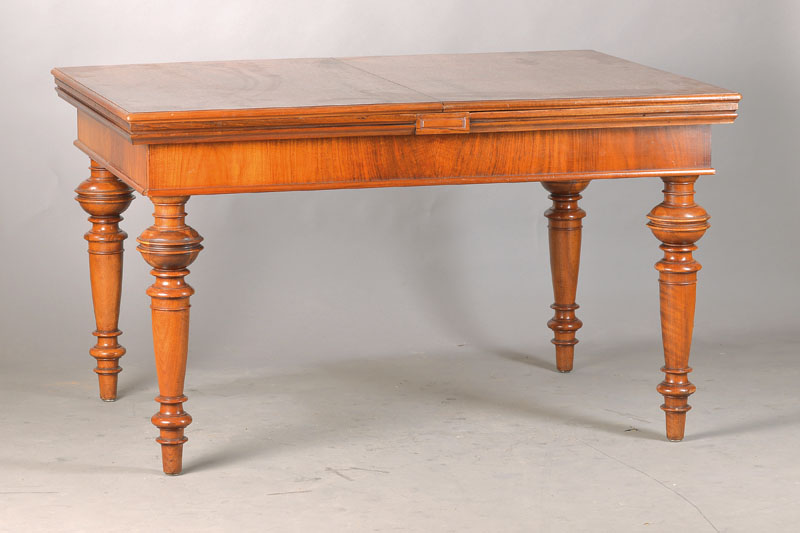 Ausziehtisch, deutsch, um 1880/90, Nussbaumfurnier, fein gedrechselte Balusterbeine, Zarge profiliert u. querfurniert, Plattenenden mit je 2 ...