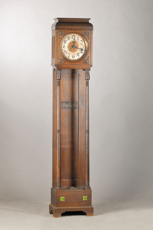 Standuhr, deutsch, 1910, dunkel gefaßtes Eichengehäuse, Schwungbereich des Pendels zwischen gerillten Vollsäulen, endent in Tulpenoptik, oben 2 ...