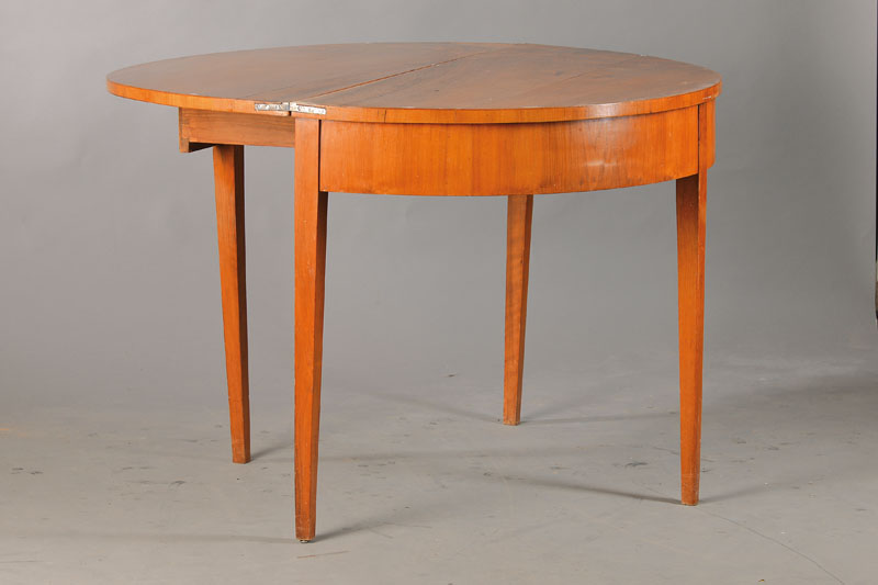 Demi-Lune-Tisch, deutsch, um 1820/30, Nussbaumfurnier auf Weichholzkorpus, konische Vierkantbeine, Zarge querfurniert, aufklappbar mit Zargenschub, ...