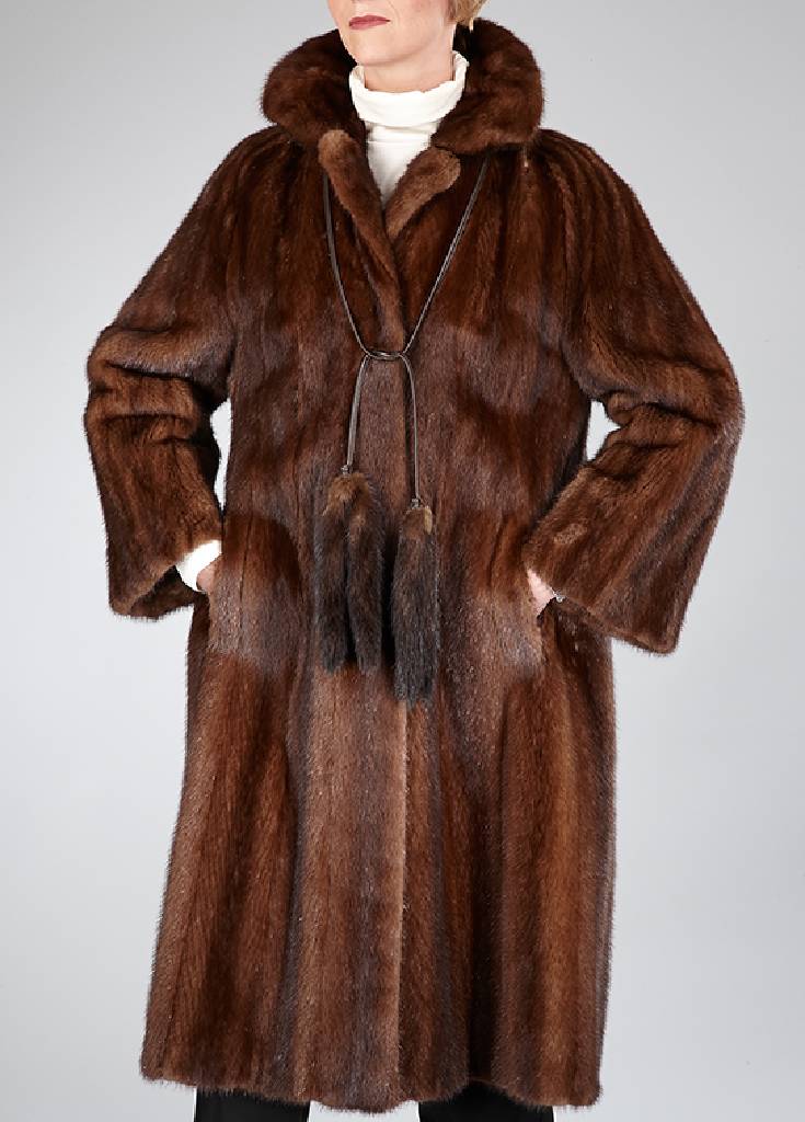 Saga Mink Nerzmantel, Gr. ca. 40, braune Felle längsverarbeitet, Reverskragen mit Nerz-schwänzen an Lederband, 2 seitl. Einschubtaschen, braunes ...