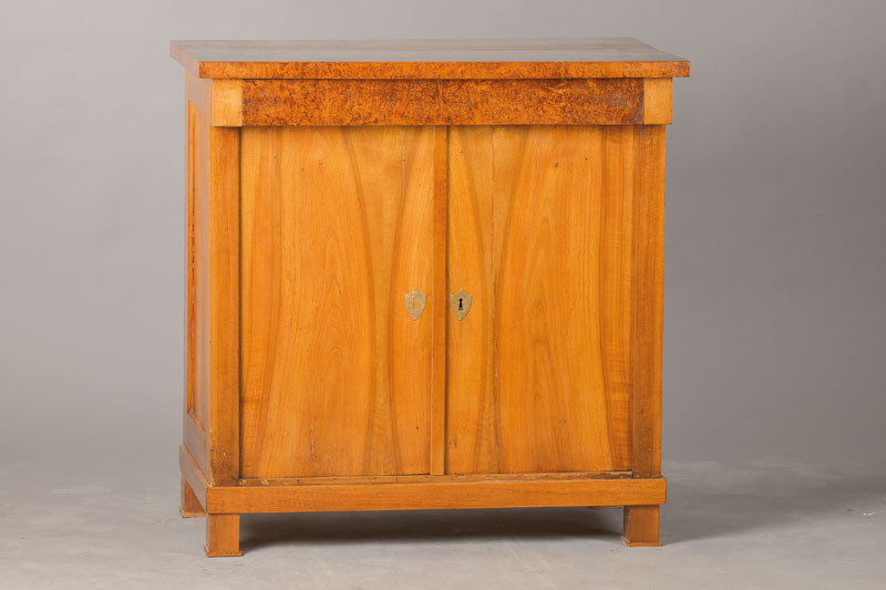 Halbschrank, deutsch, um 1810/20, 2-türig mit Kopfschub, Nussbaum, Platte u. Schubladenfront in Wurzelmaserholz, ca. 90x87x51 cm