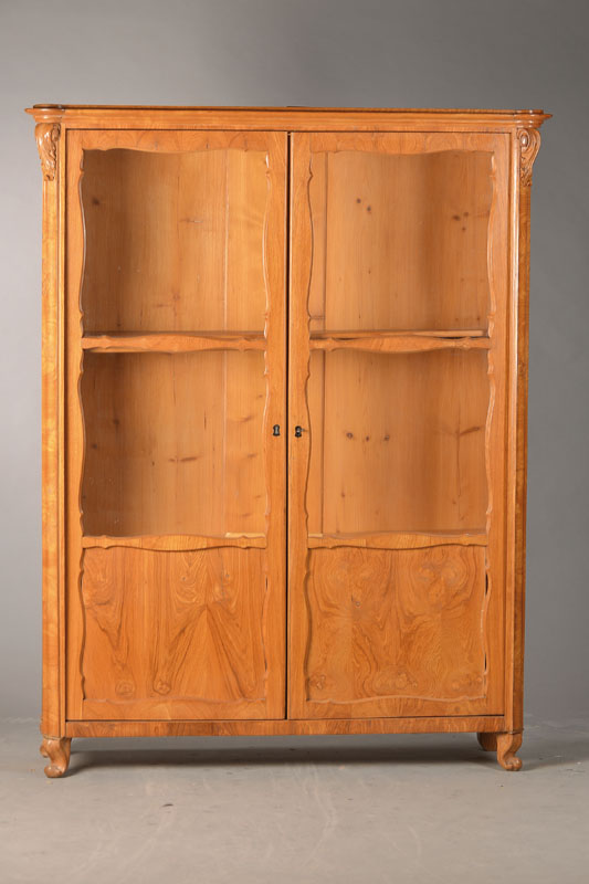 Vitrine bzw. Bücherschrank, wohl Österreich, um 1840/50, Eschefurnier, sog. Maserholzfurnier bzw. Blumenesche, Brezelfüllungen, 2-türig, Ecken ...