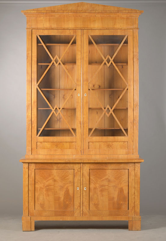 Hochbürgerliche Aufsatzvitrine, wohl Sachsen, um 1830, Birkefurnier auf Weichholzkorpus, 2-türiger Unterschrank, 2-türiger Aufsatz mit Spitzgiebel ...