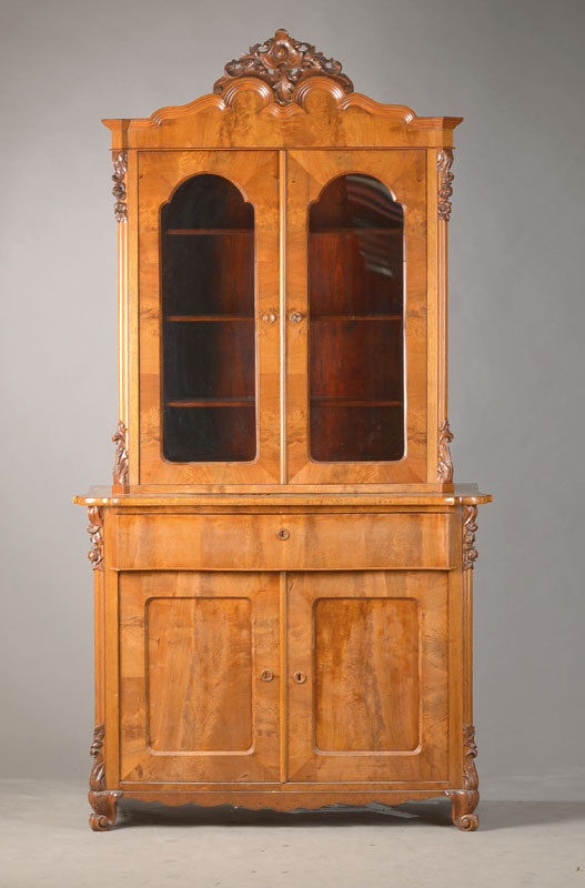 Aufsatzvitrine, wohl Sachsen, um 1860, Mahagonifurnier, 2-türiger u. 1-schübiger Unterschrank mit seltener gewölbter Form, Aufsatz 2-türig u. ...