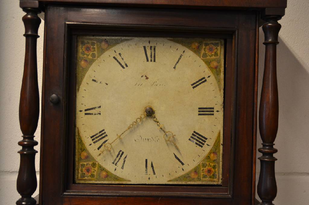 Detail a: Standuhr, England, um 1820/30,, helles Eichengehäuse, Sockel mit Spannungsrissen, Verzierung zwischen Sprenggiebel und Türglas fehlen, untere ...