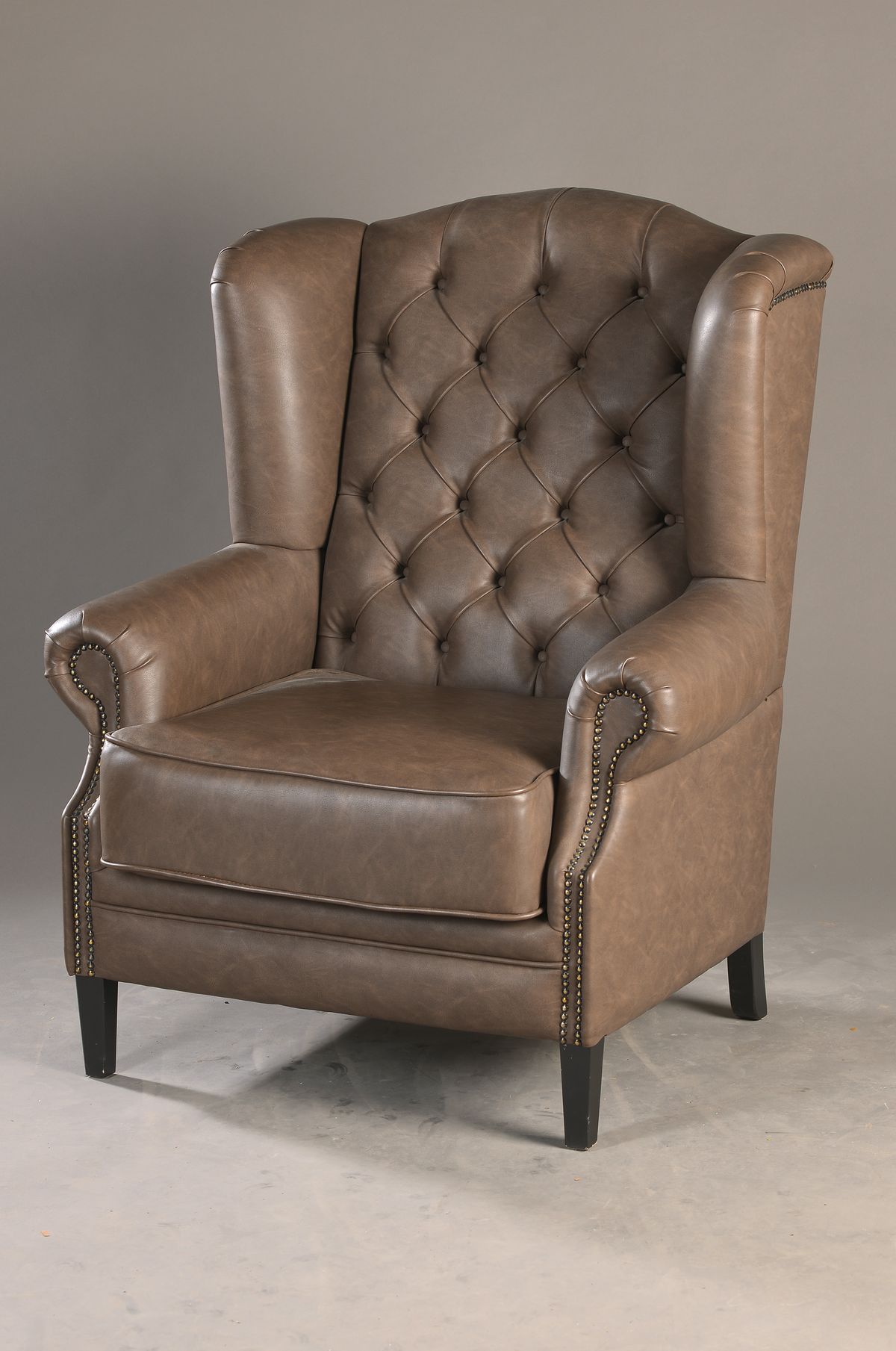 Ohrenbacken-Chesterfield-Sessel, neuzeitlich, Kunstlederbezug, vielfach geheftet mit Ziernieten, stilübliche Aufmachung, Polster u. Bezug mit ...