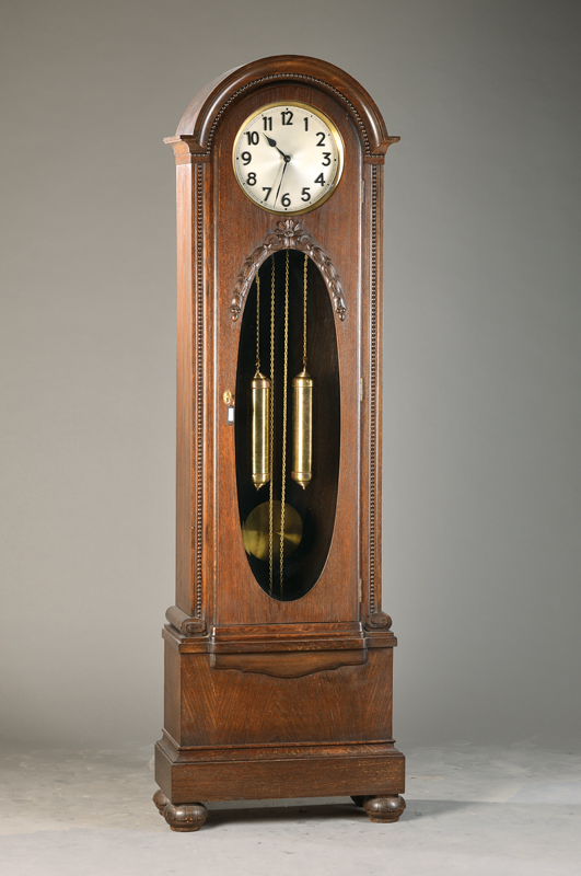 Standuhr, Junghans, um 1925/30, mass. Holzgehäuse mit Schnitzarbeiten im Stil der Zeit, Profilierungen, Perlleistendekor, im Sockel mit Voluten, ...