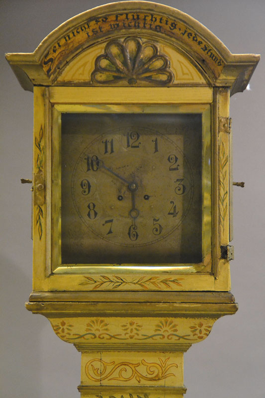 Detail a: Standuhr, Barock, mit ergänztem Werk, um 1760, Holzgehäuse, reich profiliert, gebauchter Sockel mit Adelswappen, aufgesetztes Oberteil, sekundär ...