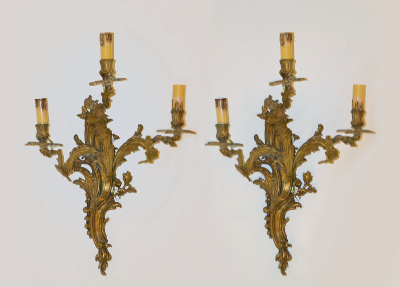 Paar Wandleuchten, Rokokostil, Mitte 20. Jh. Gelbguß in Rocaillenform, je drei Brennstellen, Elektr. nicht geprüft, H. ca. 60cm