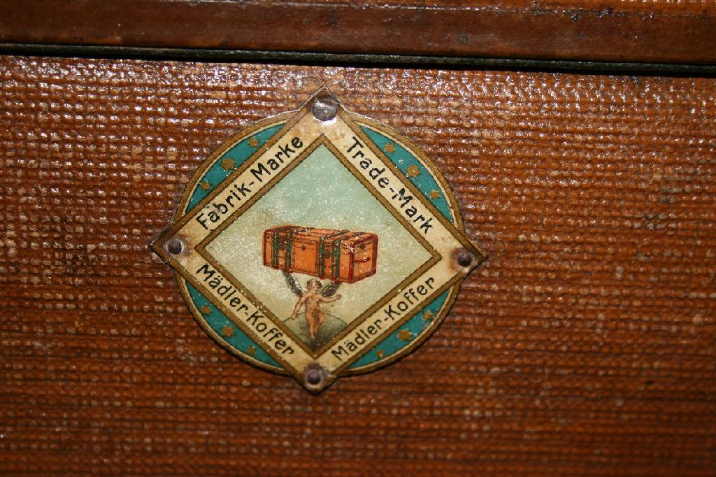 Detail c: Mädler Kofferfabrik Leipzig, um 1925, wasserfester Leinenbezug mit Lederkante, Innen original Ledermarke, Außen zwei original farbige Blechschilder ...