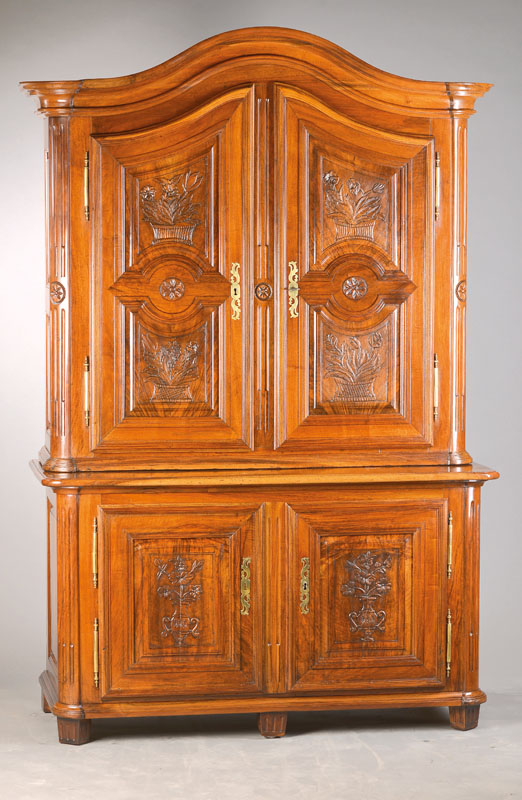 Aufsatzschrank, wohl Freiburg, um 1770/80, Nussbaum massiv, 2-teilig, Unter- und Oberteil je 2-türig, floral aus dem Vollholz geschnitzte Kassetten, ...