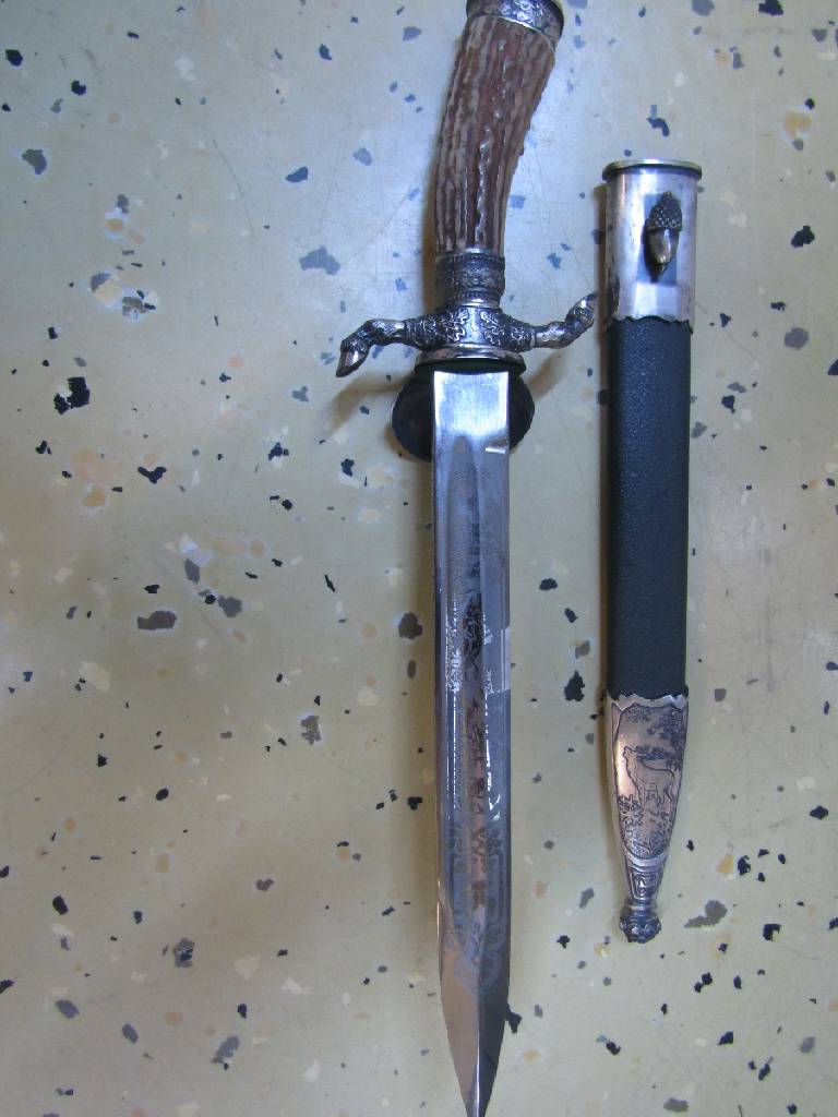 Detail a: Hirschfänger, deutsch/Solingen, 50er Jahre, Bakelitgriff mit erhabenem Eicheldekor, z.T. mit Bronzeverzierungen, Scheide mit Hirschdarstellung, ...