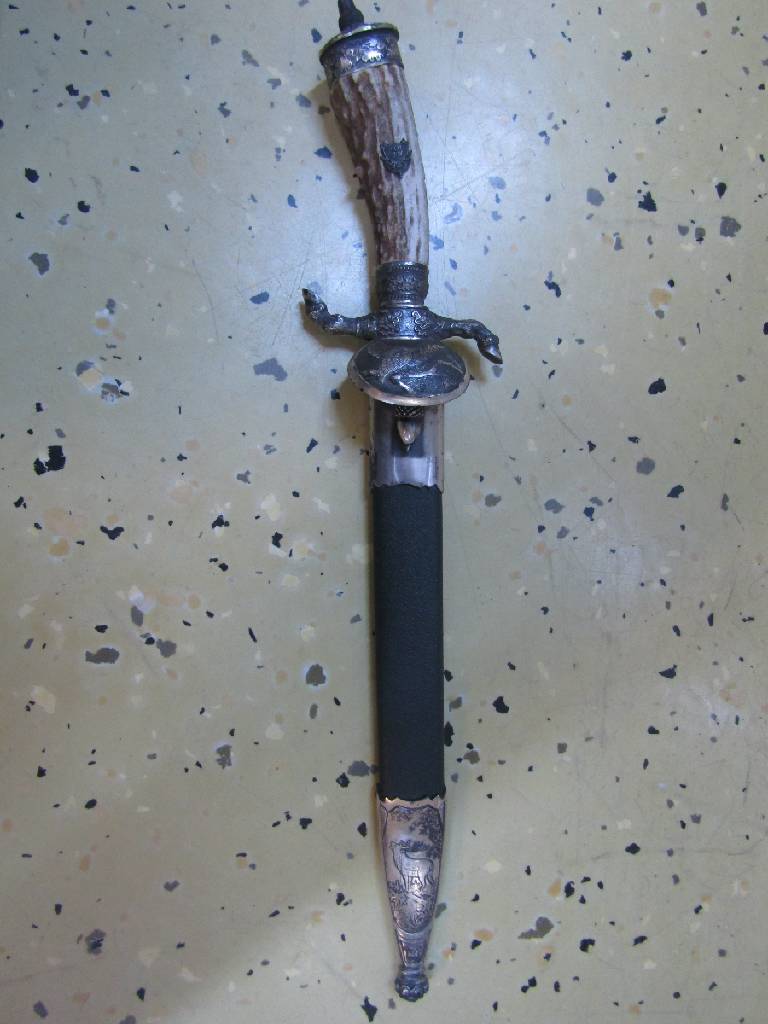 Detail b: Hirschfänger, deutsch/Solingen, 50er Jahre, Bakelitgriff mit erhabenem Eicheldekor, z.T. mit Bronzeverzierungen, Scheide mit Hirschdarstellung, ...