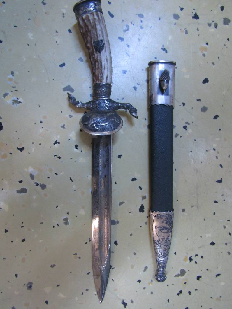 Detail c: Hirschfänger, deutsch/Solingen, 50er Jahre, Bakelitgriff mit erhabenem Eicheldekor, z.T. mit Bronzeverzierungen, Scheide mit Hirschdarstellung, ...