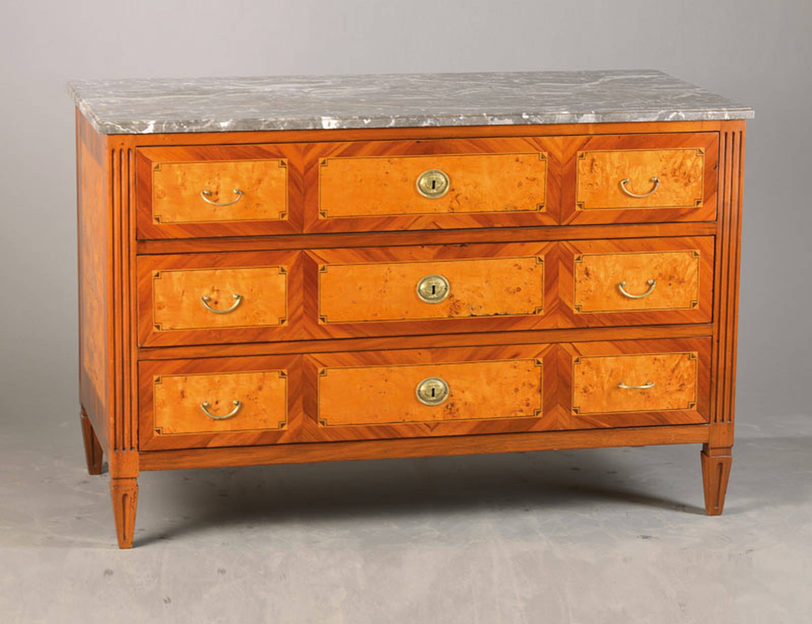 Louis-Seize-Kommode, wohl Frankreich, um 1780/90, Nussbaumrahmen, Kirschbaum auf Kreuzfuge verlegt, Weichholzkorpus, 3-schübig mit ...