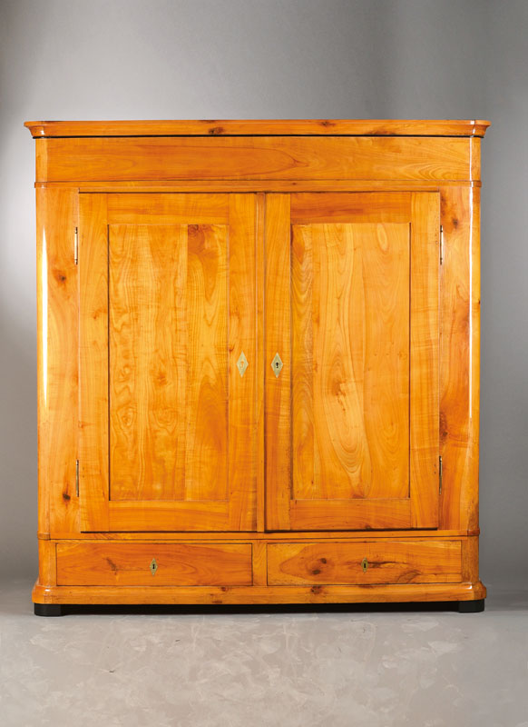 Großer Biedermeierschrank, süddeutsch, wohl Baden, um 1820, Kirschbaum massiv, abgerundeteEcken, 2-türig, 2 Sockelschübe, Innenleben mit ...