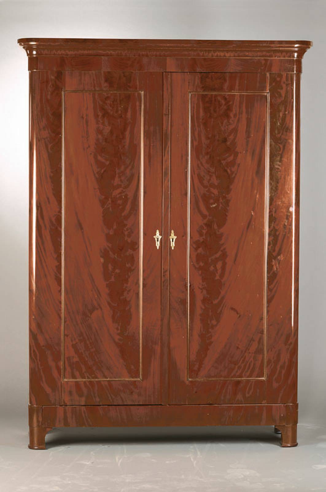 Dielenschrank, wohl Frankreich, um 1840, Pyramidenmahagoni großflächig auf Eichekorpus verlegt, abgerundete Ecken, reiches Innenleben mit ...