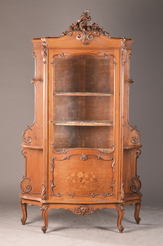 Salonvitrine, wohl Frankreich, um 1910/20, Nussbaum massiv u. furniert, 1-türiger Vitrinenkorpus mit gewölbtem Glas, Innen 3 Einlegeböden, seitl. ...