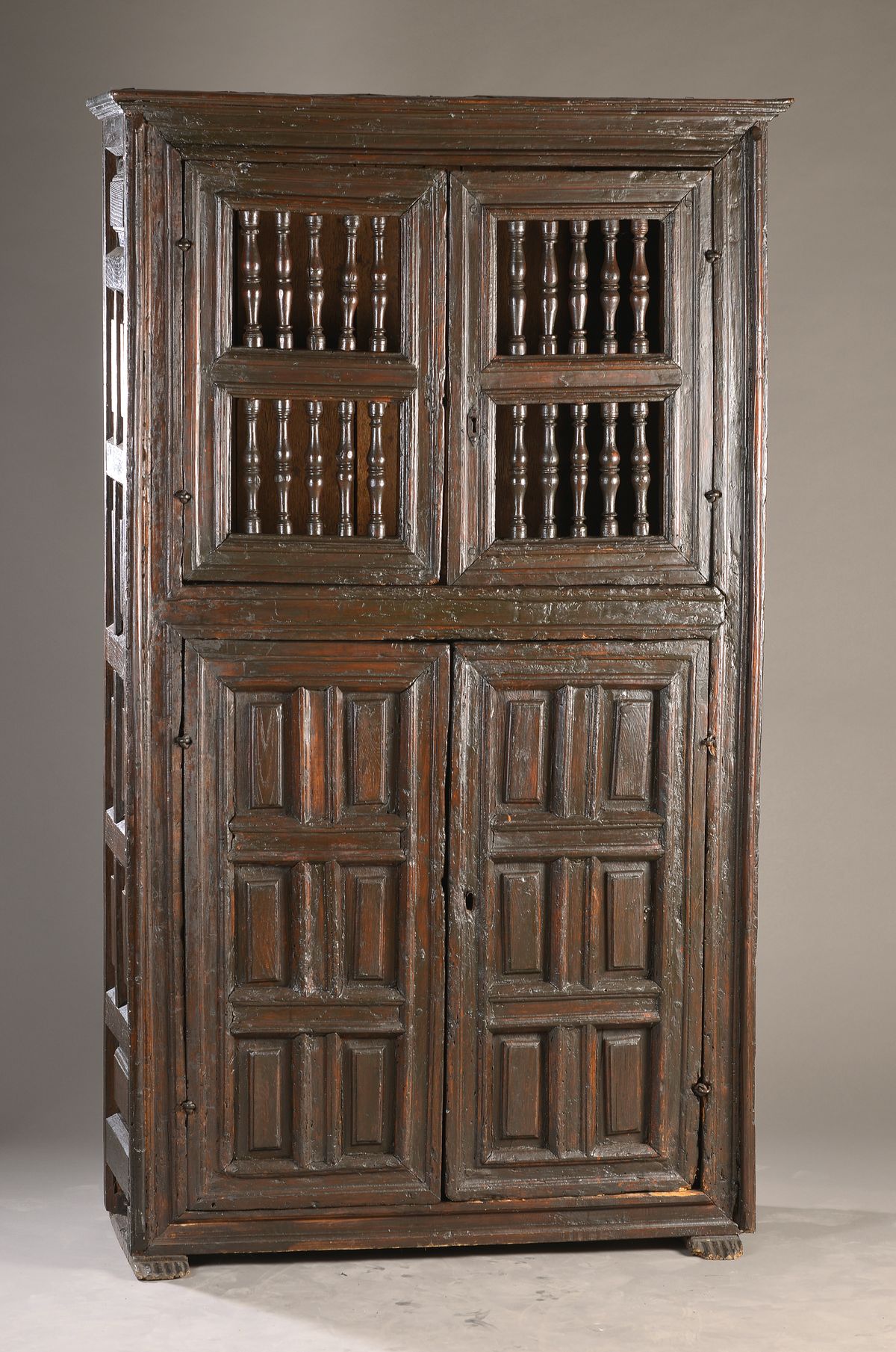 Bauernschrank, Nordspanien, 18. Jh., zweigeteilt, je zwei Türen im Unterteil und zwei Türen im Oberteil, Oberteil mit gedrechselten ...