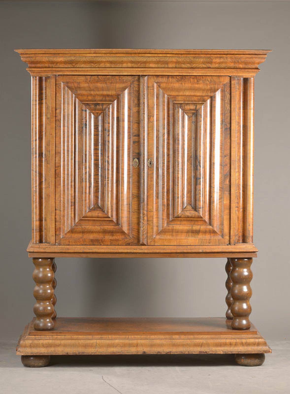Wellen- bzw. Nasenschrank als Stollenschrank, wohl Frankfurt, um 1700, Nussbaum querfurniert, 2-türig, tief eingekehlte Nasen, schöne Patina des ...