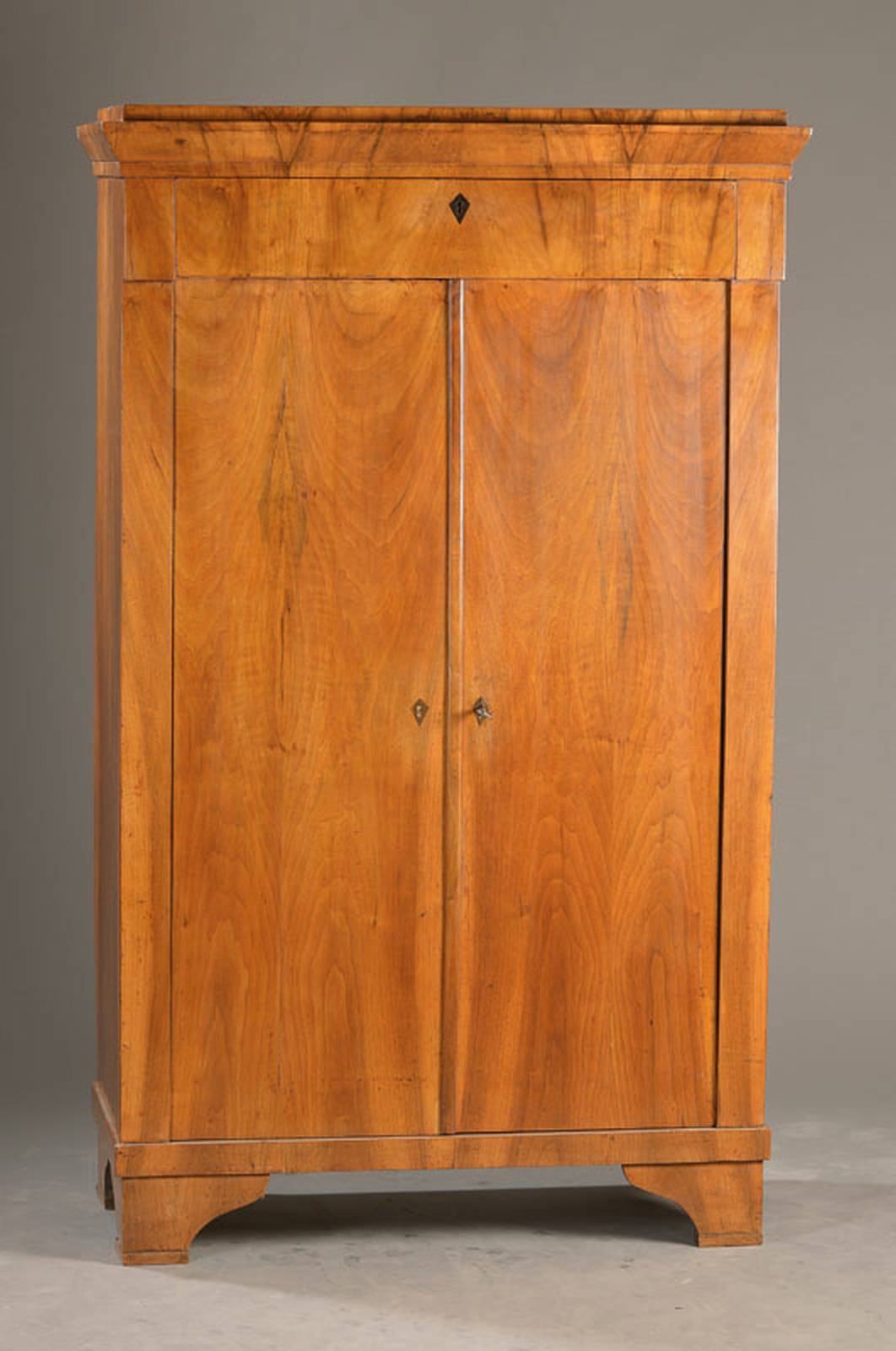 Biedermeier-Dielenschrank, wohl Österreich, um1830/40, Nussbaumfurnier auf Weichholz, 2-türig, 1- schübig, Kopf mit Kantprofil, einzelne Teile ...